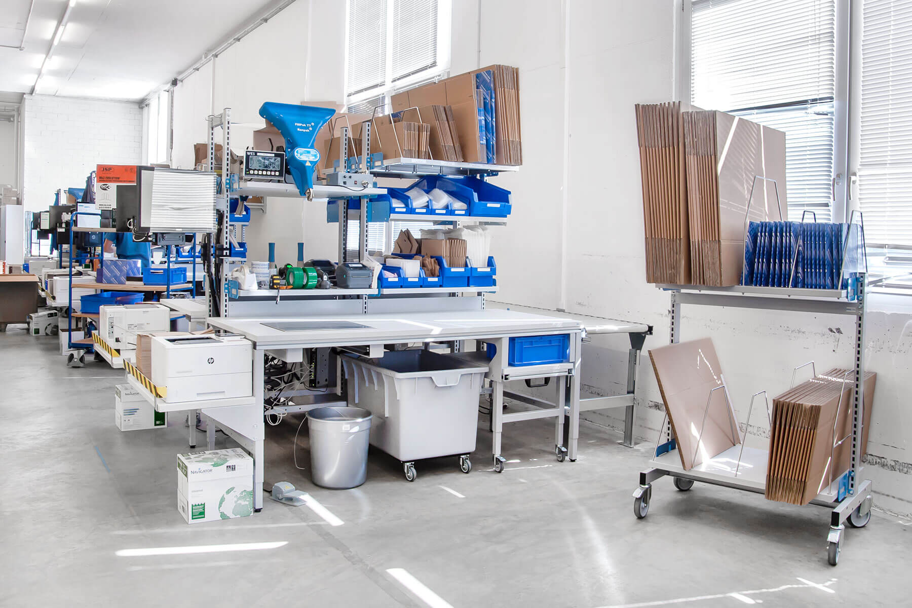 Tables d'emballage ERGO-Basic le long d'un convoyeur à rouleaux {{brizy_dc_image_alt imageSrc=